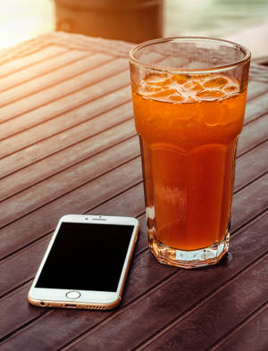 冰茶和智慧型手機在木桌上，溫暖陽光 — iPhone 6s Plus 壁紙