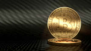 一枚帶有雕刻文字的金色比特幣硬幣直立於深色紋理表面上。 — 比特幣 GIF 壁紙