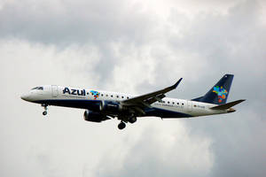 Azul Airlines飛機在雲層密佈的天空下放下起落架飛行。 — 巴西 壁紙