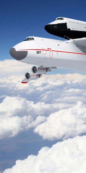 NASA太空梭載運飛機載著太空梭在雲層上方飛行 — 18:9 壁紙