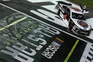 NASCAR賽車越過終點線，車手在夜間慶祝勝利。 — 賽車 壁紙