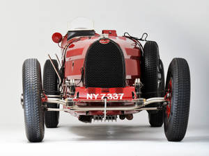 紅色復古Bugatti賽車正面視圖，帶有NY7337車牌。 — 紅色美學 iPhone 壁紙
