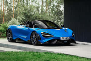 藍色McLaren 720S Spider敞篷跑車停放在戶外，靠近樹木和一座深色建築。 — 麥拉倫 壁紙