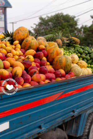 藍色貨車在戶外市場裝載熱帶水果。 — Huawei MatePad 11.5 (2025) 壁紙
