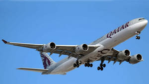 卡達航空空中巴士A380飛機在清澈的藍天中放下起落架降落 — 卡達 壁紙