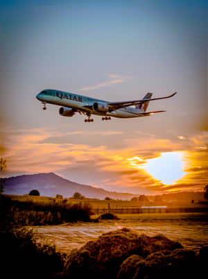 卡達航空飛機在日落時分降落於景觀之上 — 夕陽天空 壁紙