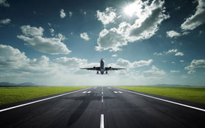 一架飛機在陽光明媚、有雲的天空下從跑道起飛。