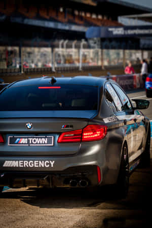 啞光灰色BMW M5賽車，帶有定制貼紙，在暮色中的賽道上。 — 小米平板 8 壁紙
