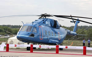 藍色Mi-38直升機停在機場，有紅色障礙物，兩名男子在附近站立。 — 海軍藍 壁紙