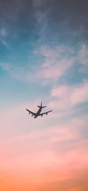 飛機飛過色彩繽紛的日落雲層 — POCO M8x 壁紙