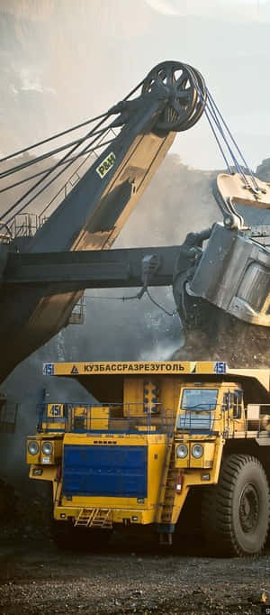 黃色礦用自卸車在露天礦場中從挖掘機裝載煤炭 — 黎明 壁紙