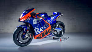 工作室環境中帶有Red Bull品牌標誌的藍橙色KTM MotoGP賽車。 — 巴布風機車 壁紙