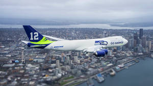 帶有Seahawks品牌的波音747飛越西雅圖城市景觀。