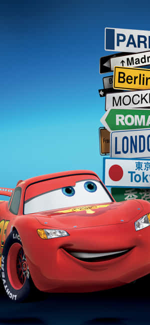 紅色動畫車有大眼睛，在彩色城市標誌附近微笑。 — 閃電麥坤 壁紙
