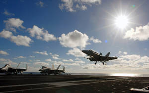 戰鬥機從航空母艦甲板起飛，背景有海洋和太陽。 — 空軍 壁紙