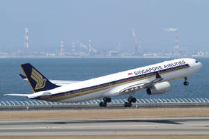 新加坡航空飛機在日落時分於工業海岸附近降落 — 城市 壁紙