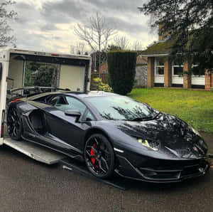黑色藍寶堅尼Aventador在拖車上，前面是郊區房屋。 — 賽車 壁紙