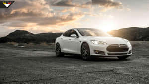 白色Tesla Model S在日落時停放在裂開的瀝青路上，背後有山丘。 — 特斯拉 壁紙