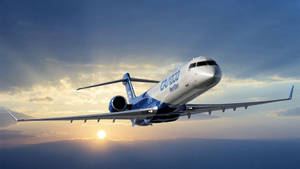 一架CRJ-900 NextGen飛機在帶有雲層的日落天空背景下飛行。