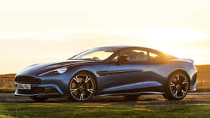 金色夕陽下停在草地上的藍色Aston Martin跑車。 — 奧斯頓馬丁 壁紙