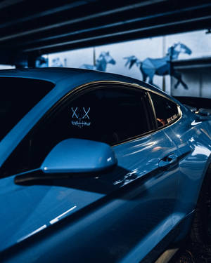 藍色跑車停放在車庫中，背景有摺紙馬雕塑。 — 淨化面具 壁紙