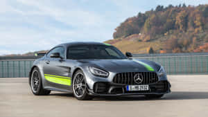 銀色 Mercedes-AMG GT R 帶有綠色賽車條紋，停在秋日山丘附近的戶外。 — Mercedes Benz C300 壁紙