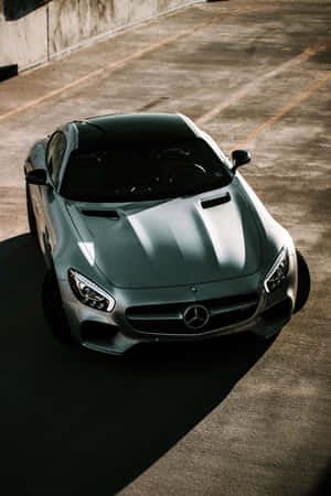 銀色 Mercedes-AMG GT 跑車停泊在混凝土停車場，帶有長長的影子。 — 小米平板 9 Pro 壁紙