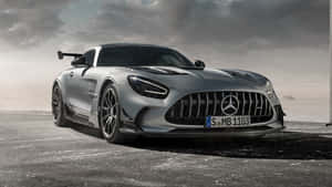 多雲天空下混凝土上的銀色 Mercedes-AMG GT Black Series 跑車。 — Pro Display XDR 壁紙