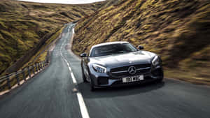 日落時分，銀色 Mercedes-AMG GT 在蜿蜒的山路上疾馳。 — Mercedes Benz C300 壁紙