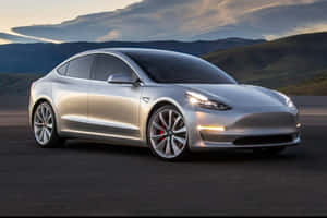 日落時分，銀色 Tesla Model 3 停泊在山路上。 — 特斯拉 壁紙