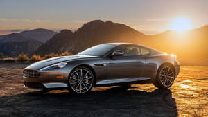 銀色Aston Martin跑車停在日落時分的山路上。 — 奧斯頓馬丁 壁紙
