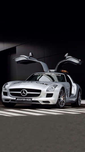 銀色賓士SLS AMG安全車，鷗翼車門打開，停在深色路上。 — 賽車 壁紙