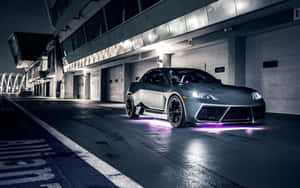 銀色跑車帶有紫色底盤燈，夜晚停放在現代車庫中。 — 馬自達 壁紙