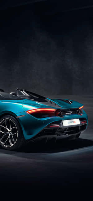 在黑暗的攝影棚環境中，帶有發光尾燈的青色McLaren 720S Spider敞篷車。 — iPhone 16 Pro Max 壁紙