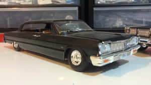 黑色1964年Cadillac模型車，帶有鍍鉻裝飾，展示在白色表面上。