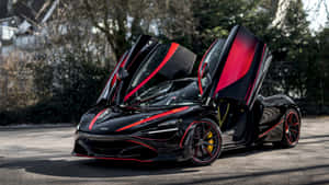 黑色McLaren跑車帶有紅色點綴和打開的車門，停泊在街道上。 — iMac 壁紙