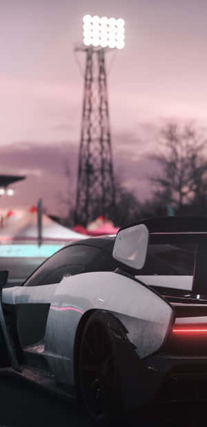 時尚的黑色賽車，在體育場燈光下帶有發光的尾燈。 — Pixel 4 壁紙
