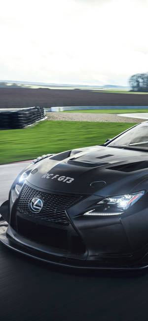 黑色 Lexus RC F GT3 賽車在賽道上奔馳，背景模糊。 — iPhone 16 Plus 壁紙