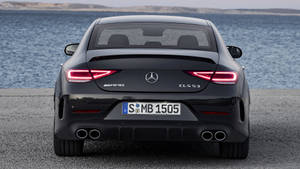 黑色Mercedes-AMG CLS 53停在近水處，尾燈發亮。 — Mercedes Benz C300 壁紙