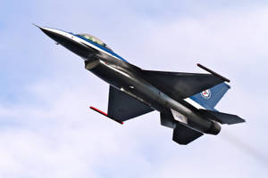 一架戰鬥機在多雲的天空中攀升。 — 空軍 壁紙
