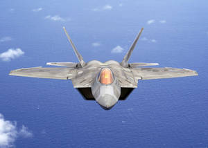 灰色戰鬥機飛越藍色海洋與白色雲朵 — 空軍 壁紙