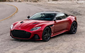 紅色Aston Martin跑車在沙漠公路上，帶有黃線。 — 奧斯頓馬丁 壁紙