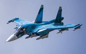 藍色軍用飛機在清澈的天空下飛行，機翼下掛載飛彈 — 軍事動圖 壁紙