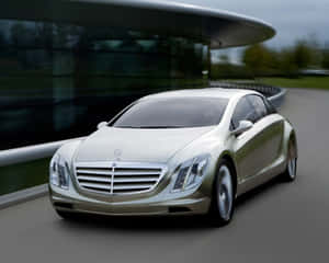 銀色豪華車在彎曲道路上高速駛過現代玻璃建築。 — Mercedes Benz C300 壁紙