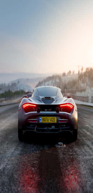 日落時分，銀色McLaren跑車在白雪覆蓋的山路上行駛。 — 雪景 GIF 壁紙