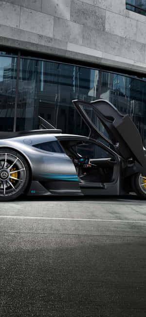 銀色跑車打開鷗翼車門，停泊在玻璃建築前。 — 電玩遊戲 GIF 壁紙