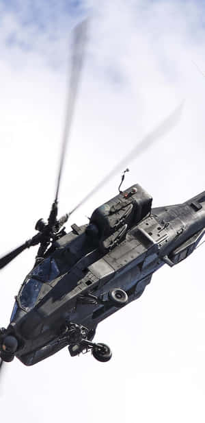 黑色軍用直升機在旋轉葉片下飛越多雲天空。 — 直升機 壁紙