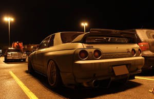 一架消光灰色日產Skyline R32在夜晚停放在停車場的街燈下。 — 夜晚 壁紙