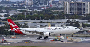 澳洲航空飛機在機場跑道滑行，背後有城市天際線 — 伸展台 壁紙