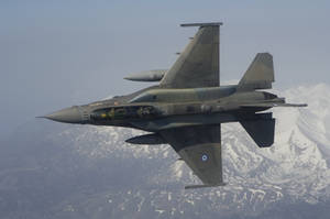 灰色戰鬥機飛越雪山，駕駛艙內飛行員可見。 — 空軍 壁紙